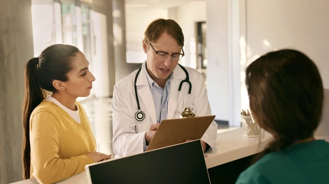 Doctor consulting with a patient at reception desk